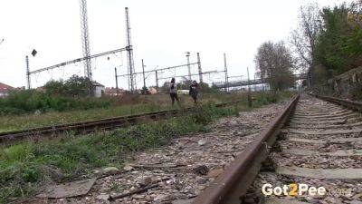 Watch these kinky girls get soaked in pee while getting frisky on the railway - sexu.com